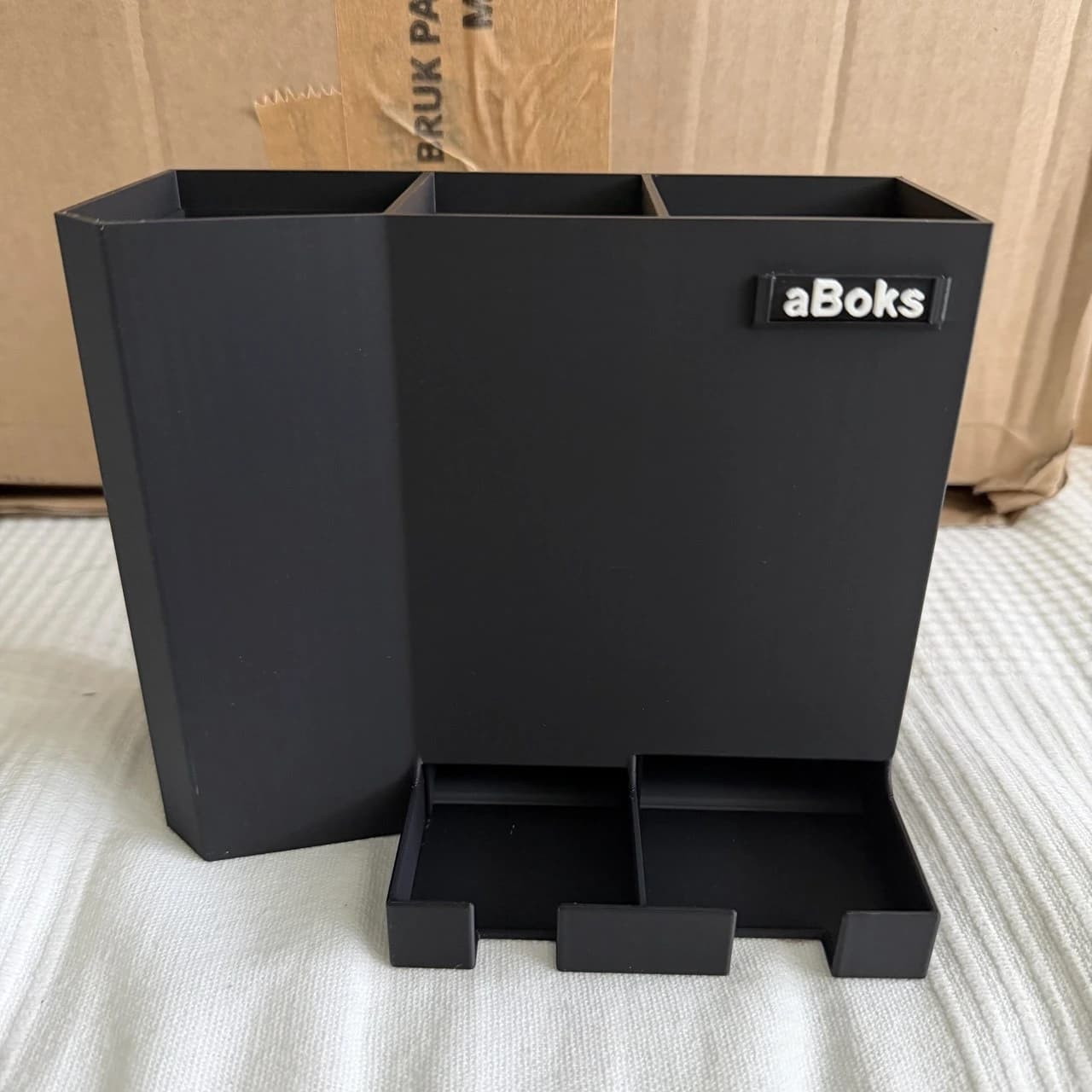 Ferdig aBoks i sort med aBoks-logo og uttaket for batterier nederst